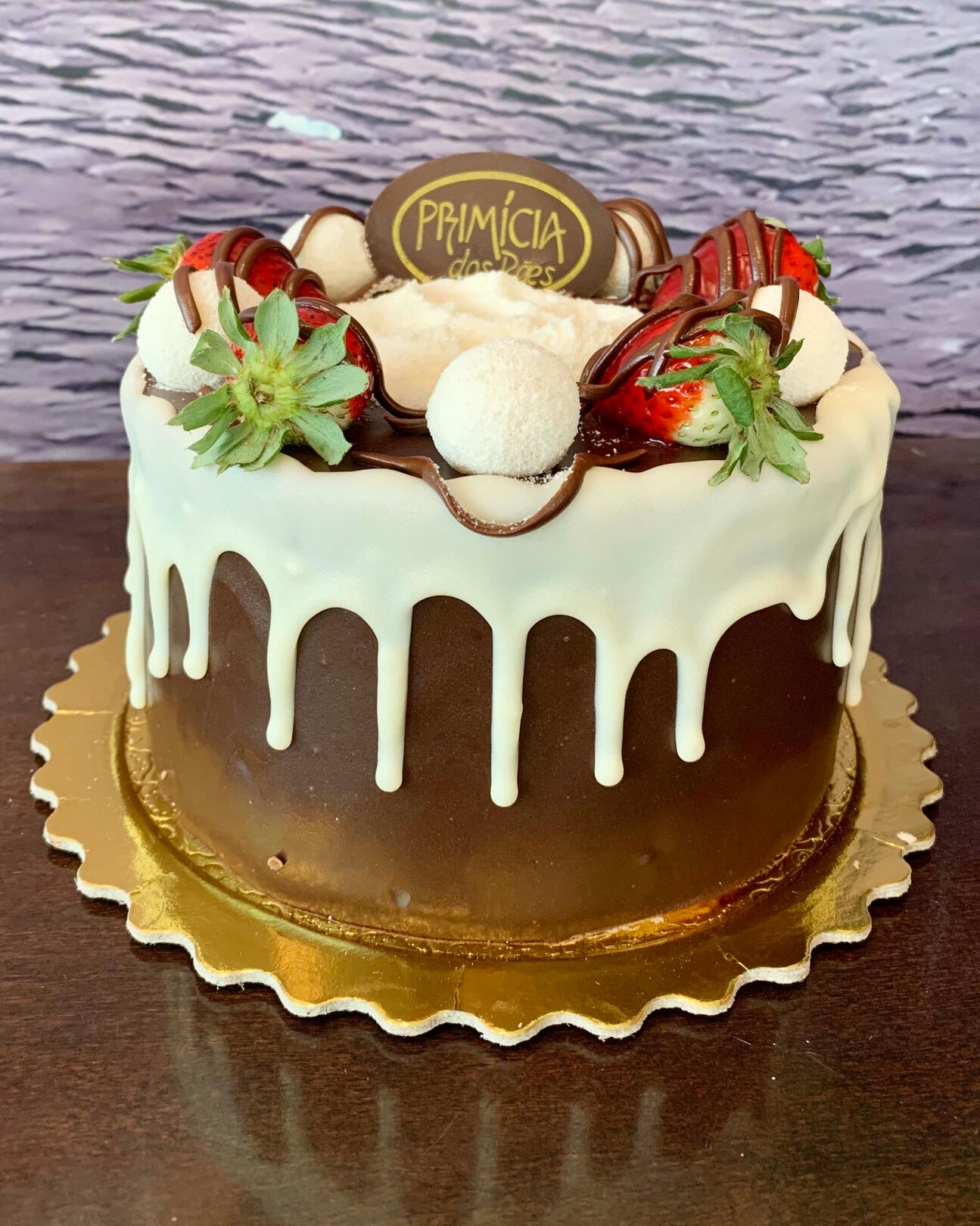 2821-LEITE NINHO COM AVELÃ Pão de ló preto, recheio de Leite Ninho com Nutella e morango picados, cobertura ganache e decorado com chocolate branco, leite em pó e morango.