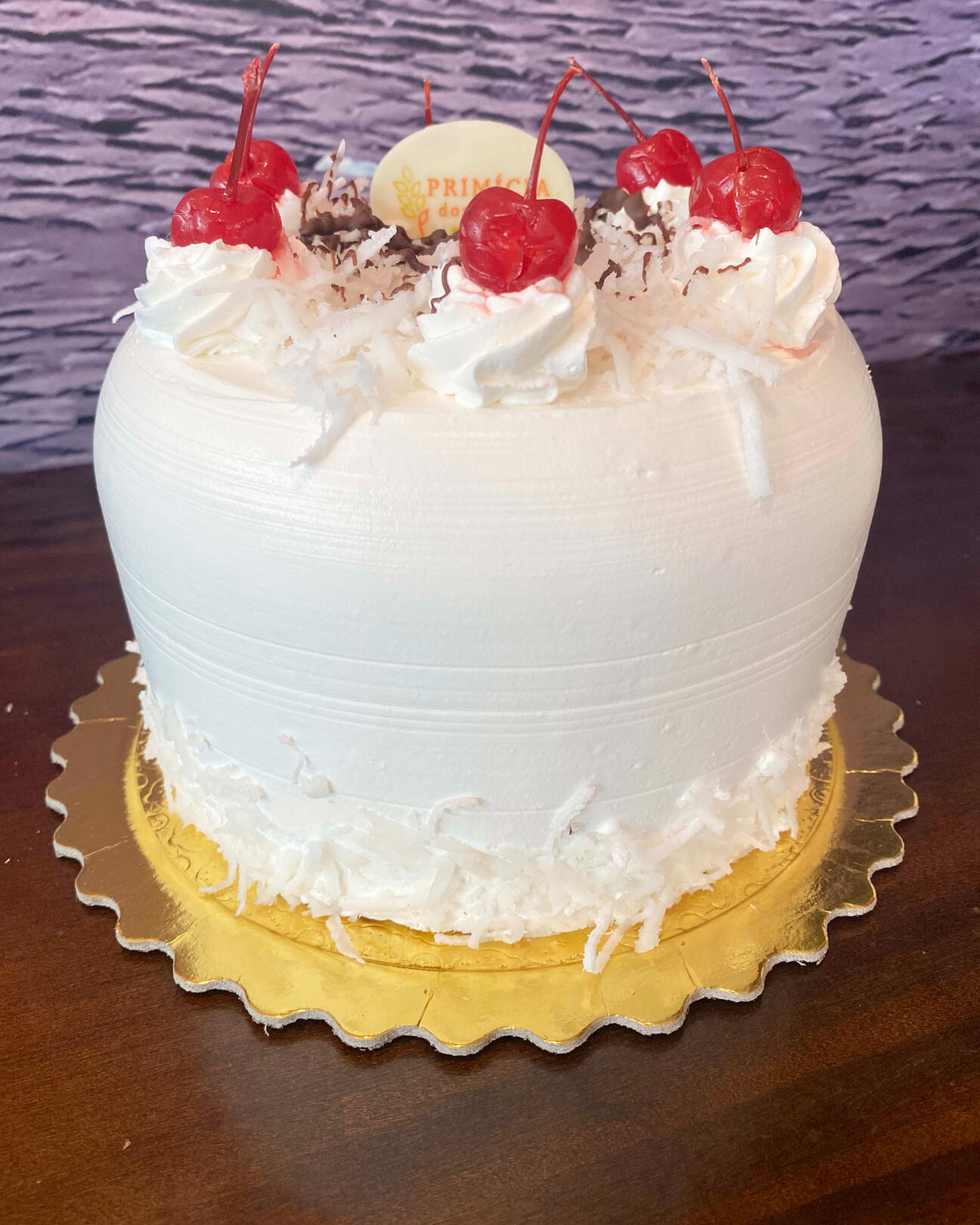 401- COCO Massa de pão de ló branco. Recheado com creme diplomata e coco. Coberto com chantilly. Decorado com coco fresco e cerejas.