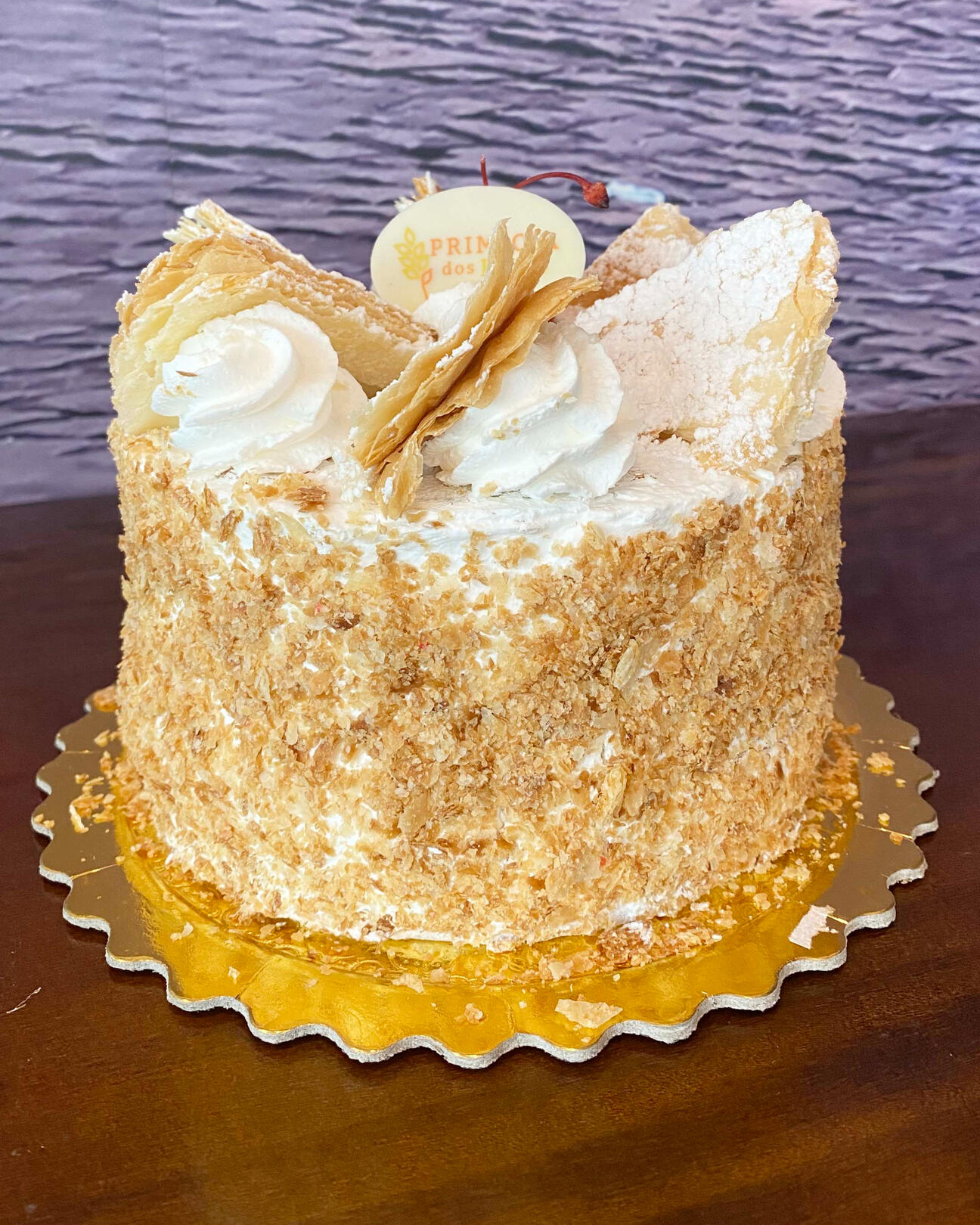 57-MIL FOLHAS Massa folhada, recheada com chantilly e creme baunilha, coberto com açúcar de confeiteiro.