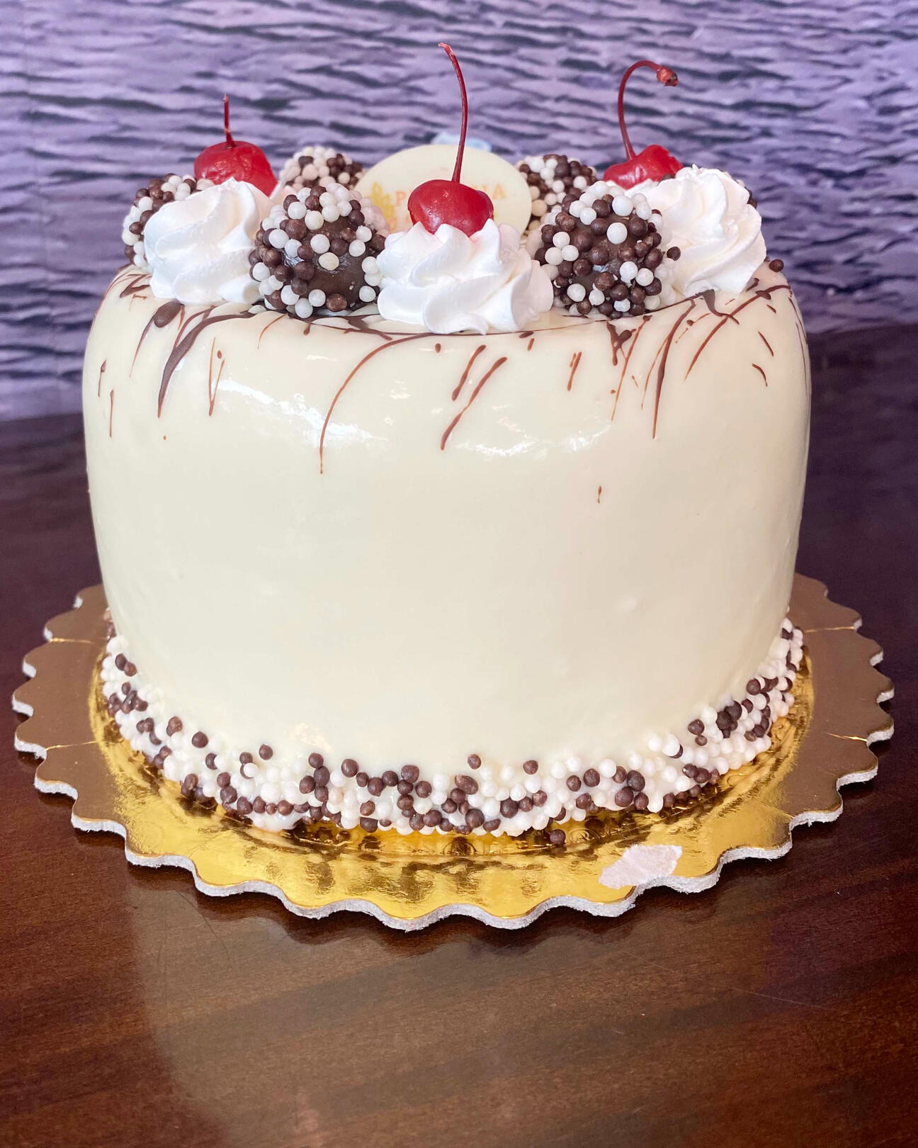 415-CHOCOBOL Pão de ló de chocolate , recheado com creme de brigadeiro, coberto com chan- tilly, decorado com bolinhas de choco ball e brigadeiro de choco ball.